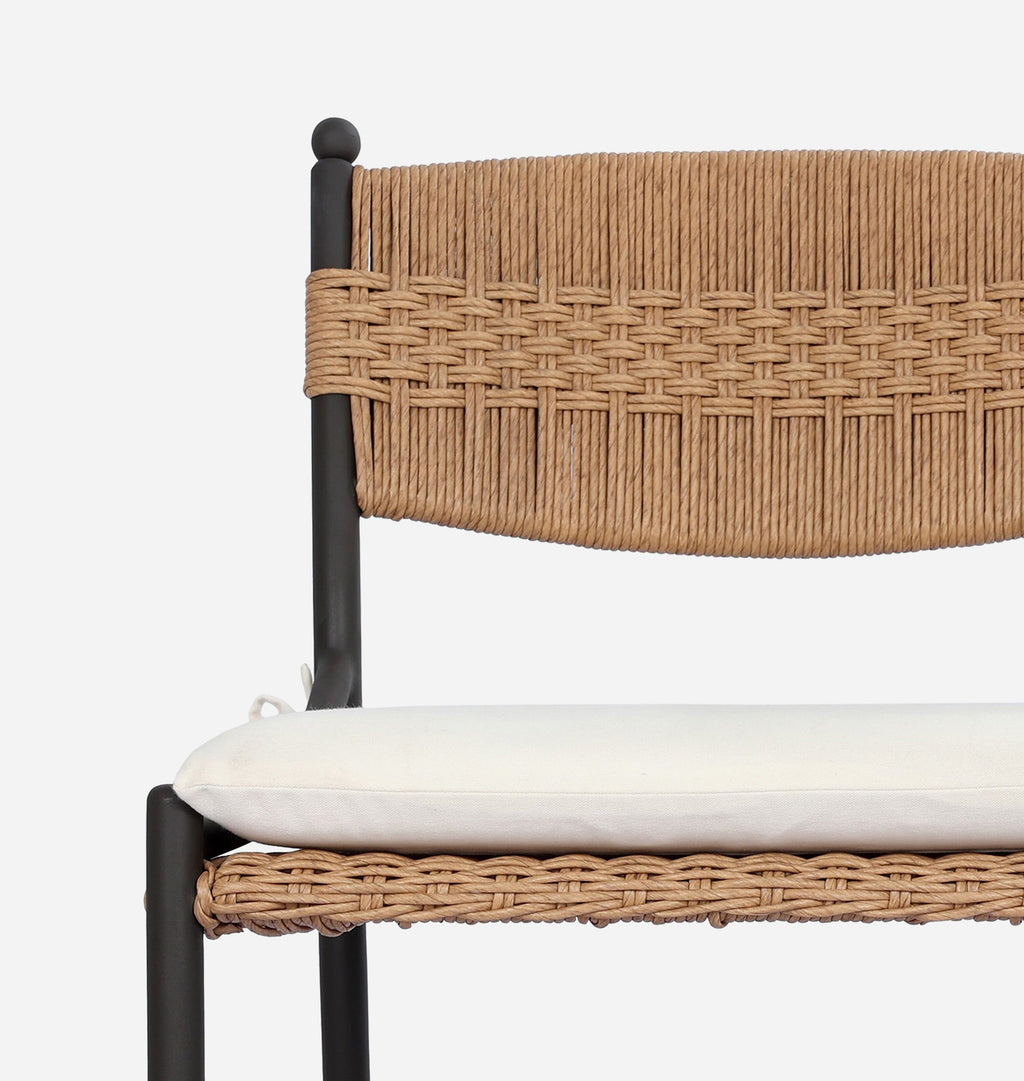 Close-up of a woven chair backrest and seat cushion on a light gray background.