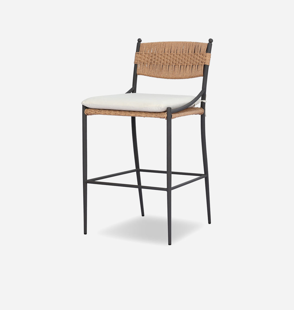 A modern bar stool with a black metal frame, woven natural backrest and seat, and a light beige cushioned seat, shown on a light gray background.