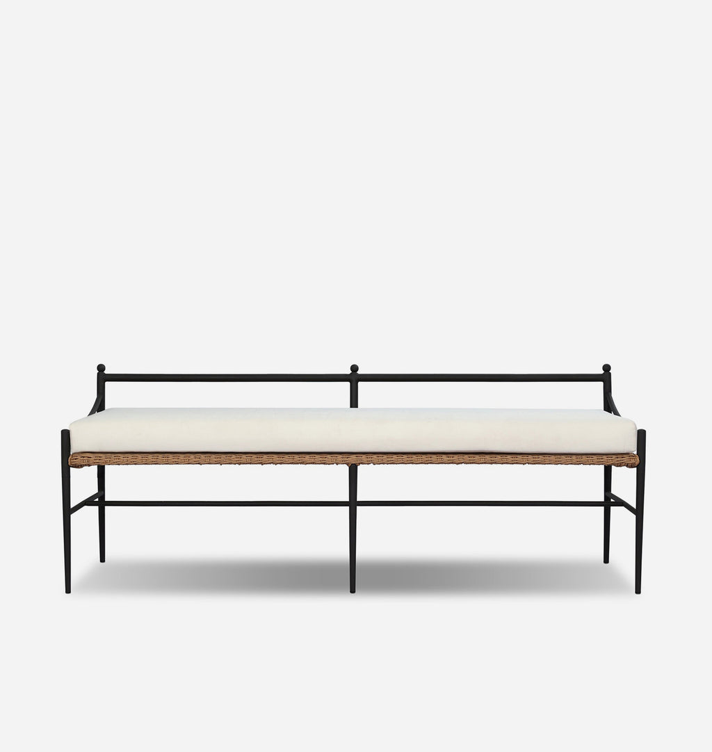 A modern bench with a black metal frame, a light beige cushion, and a natural woven rattan seat strip, shown against a plain light gray background.