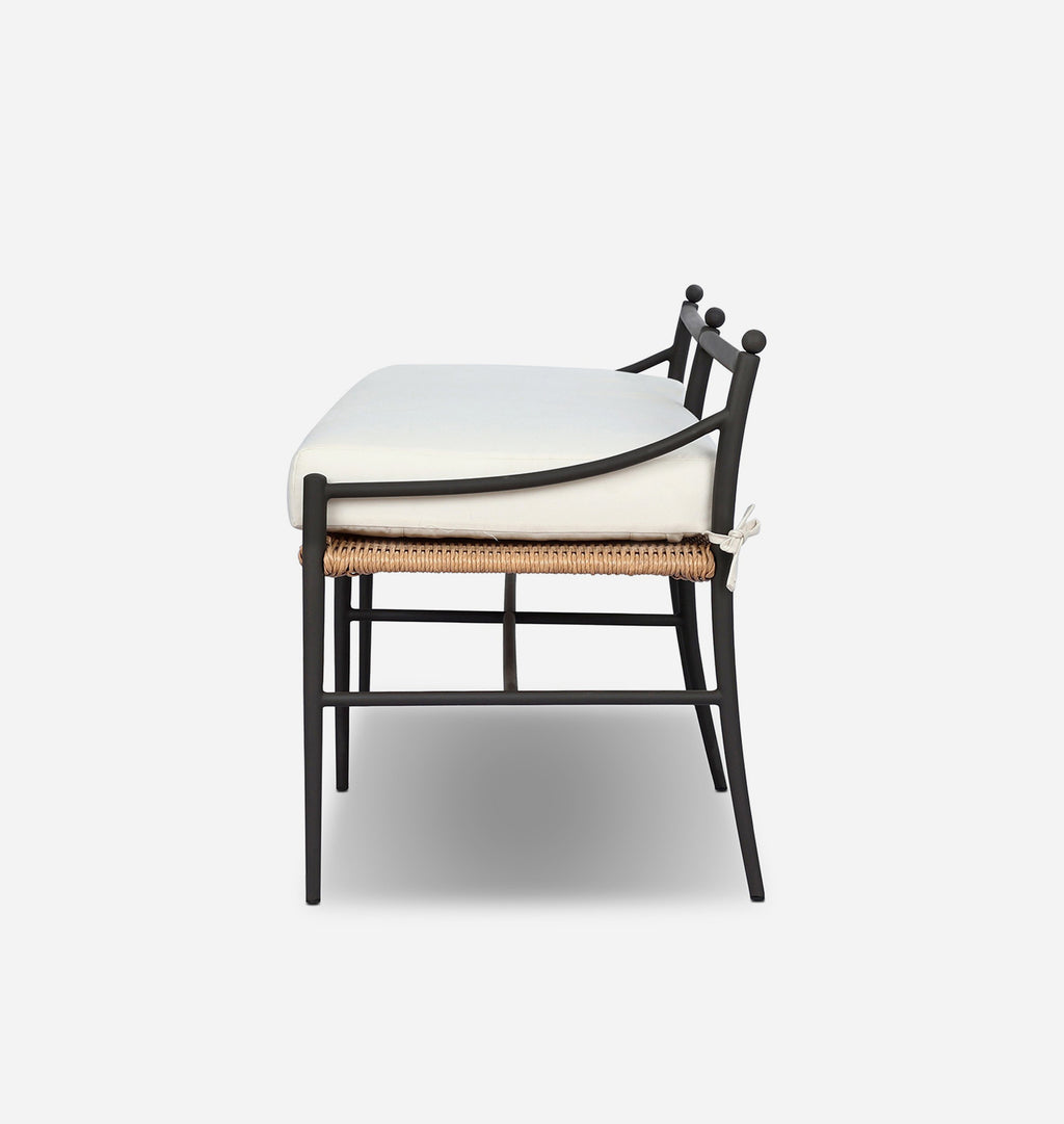 A modern outdoor dining chair with a black metal frame, a white cushioned seat, and a natural woven rattan seat rail, shown from a side angle against a light gray background.