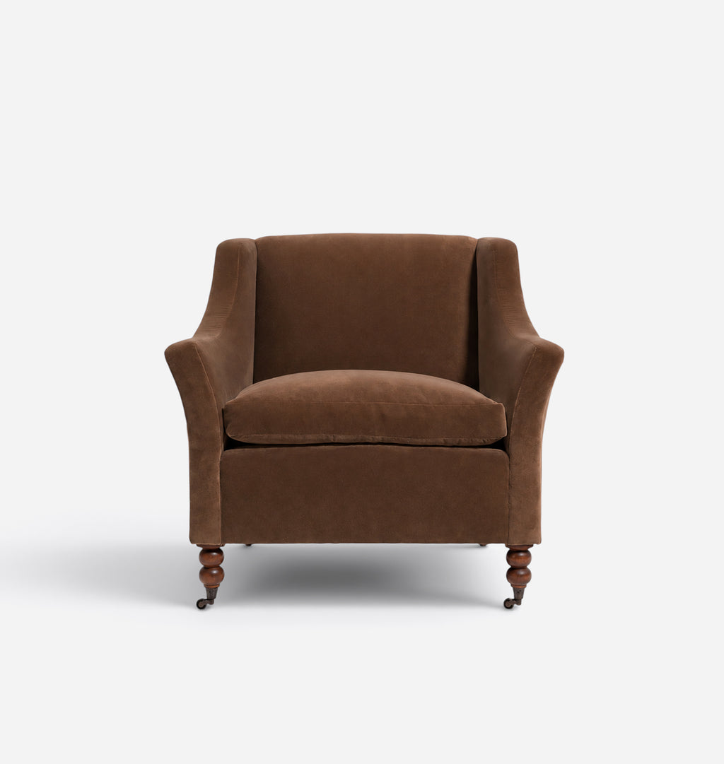A classic brown velvet armchair with turned wooden legs, shown from a straight-on perspective against a clean white background.
