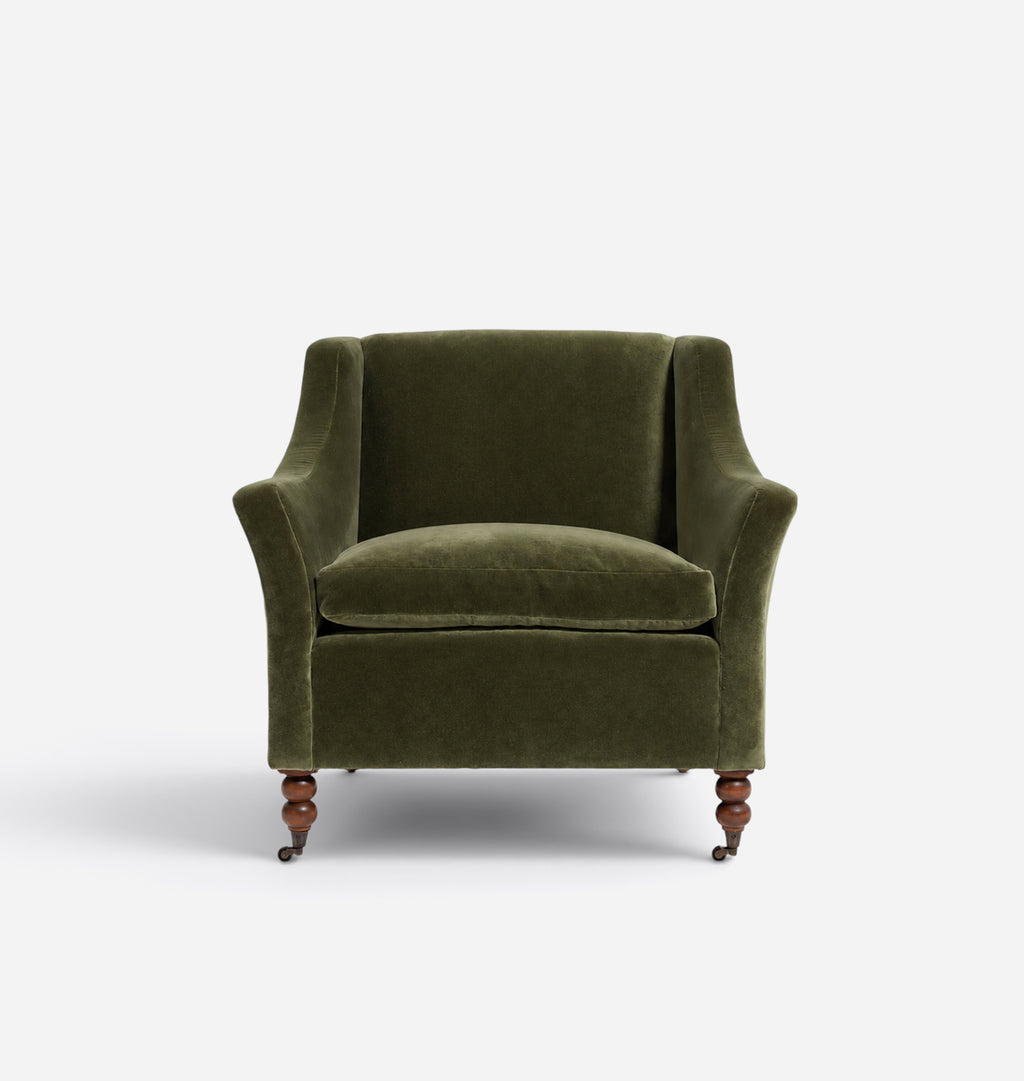 An olive green velvet armchair with turned wooden legs, photographed from the front against a plain white background.