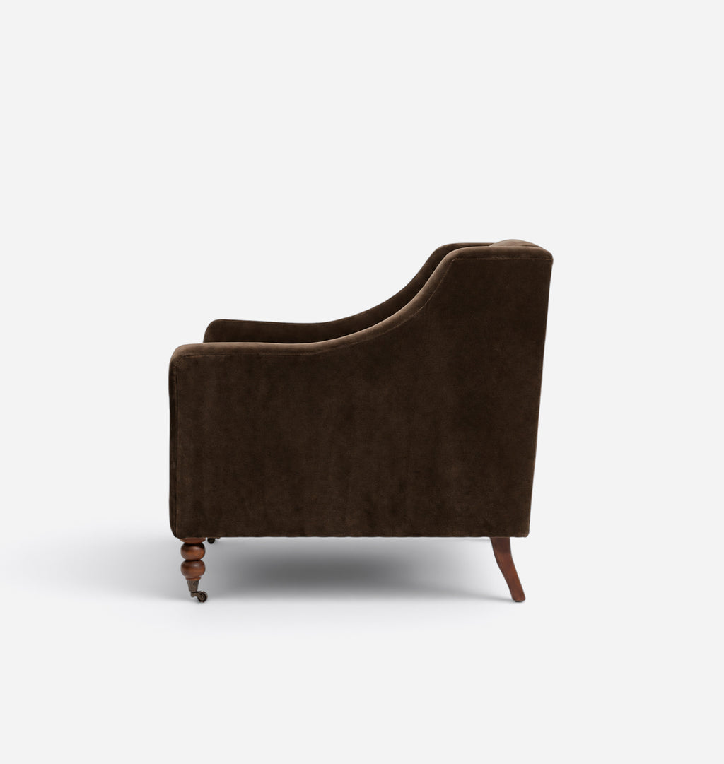 A dark brown velvet armchair shown from a side profile view against a clean white background.
