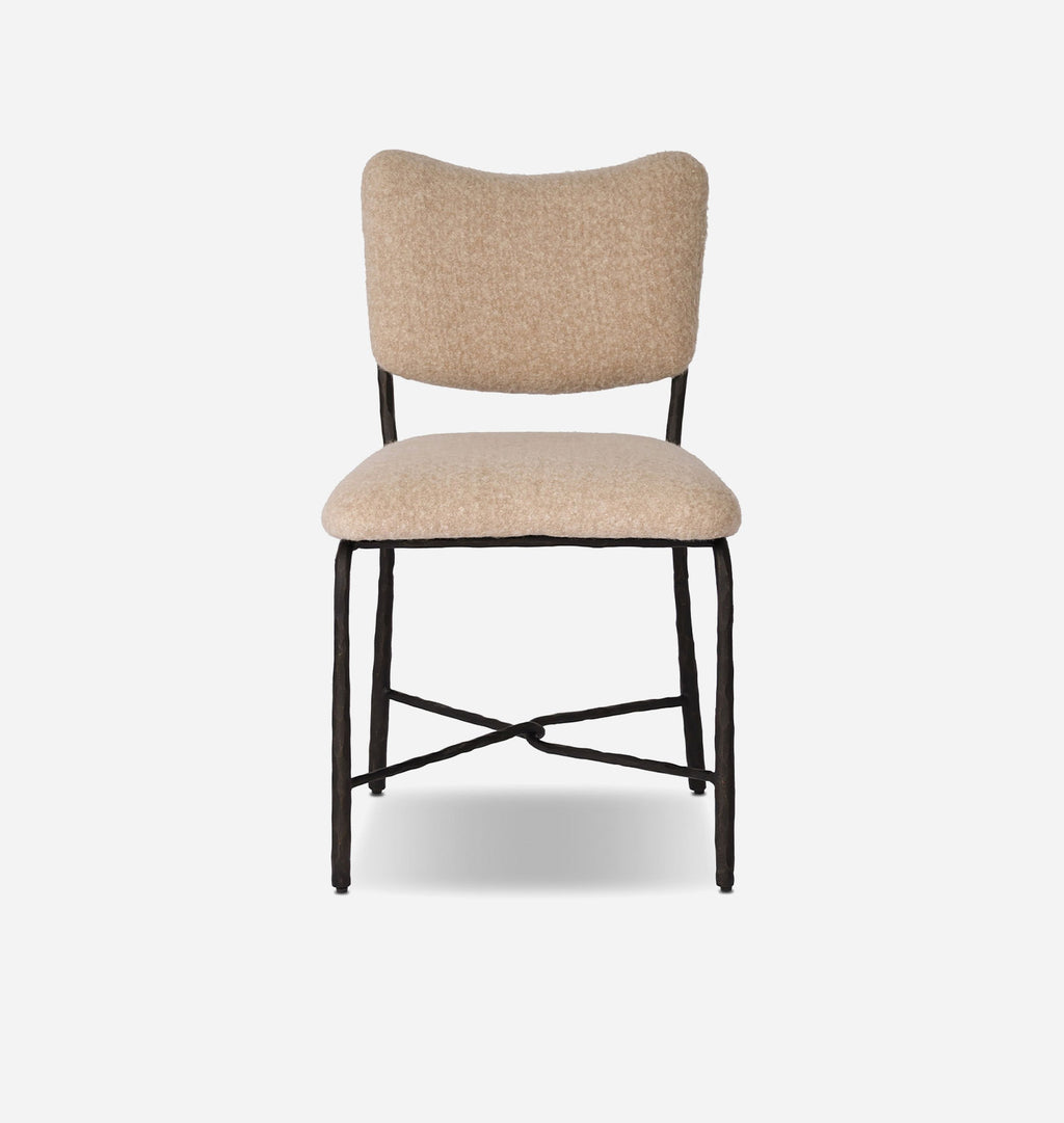 A modern dining chair with a textured beige bouclé upholstered seat and curved backrest, supported by a black metal frame with crossed legs.
