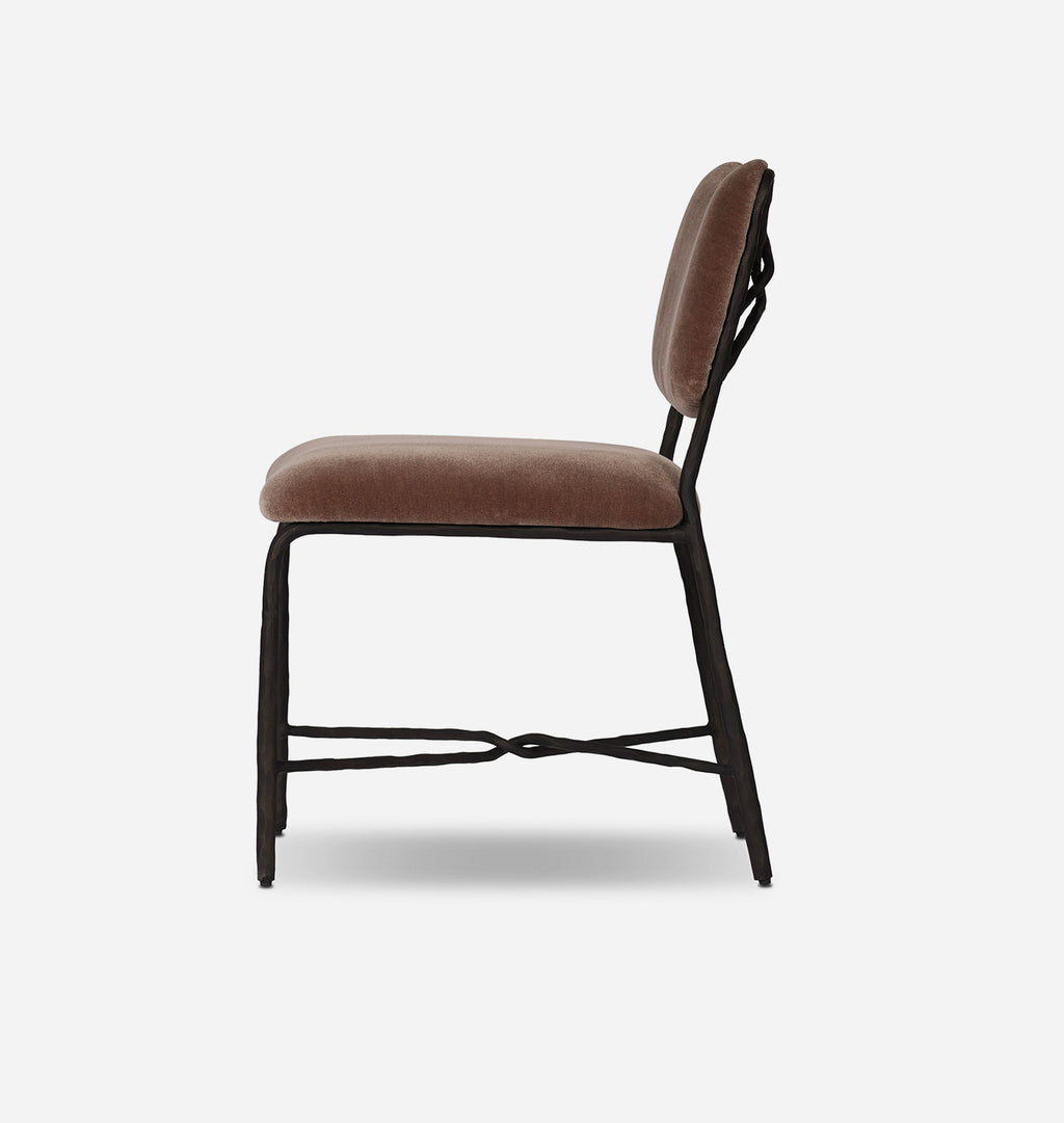 A modern dining chair with a brown velvet upholstered seat and backrest, supported by a black metal frame with a decorative crossbar design on the legs, shown from a side profile against a light gray background.