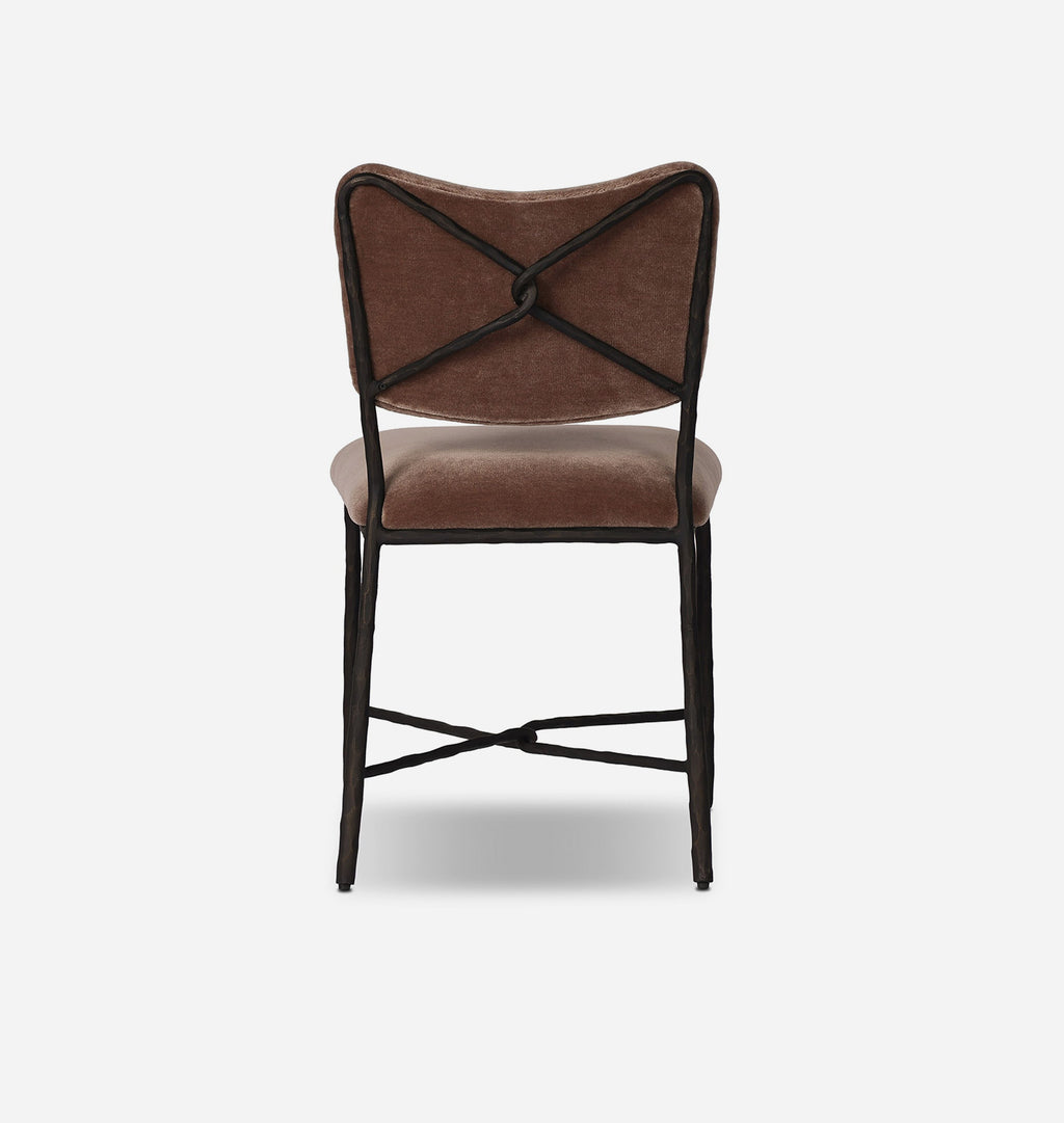 A modern dining chair with a brown velvet upholstered seat and backrest, featuring a black metal frame with an X-back design and crossed leg supports, shown against a plain white background.