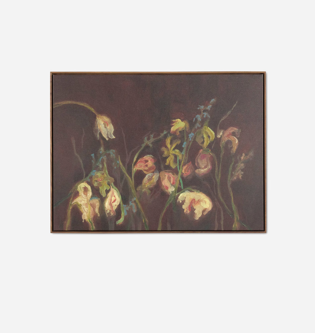 A framed painting depicting a cluster of pale yellow and pink flowers with green stems against a very dark brown background, shown on a light gray wall.