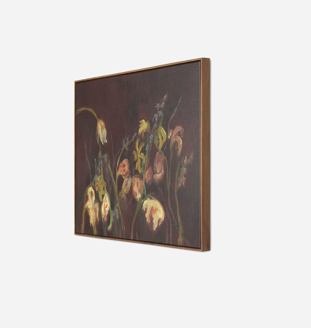 A framed square canvas painting featuring a dark floral still life with cream, pink, and yellow flowers against a deep brown background, shown at an angle on a light gray wall.