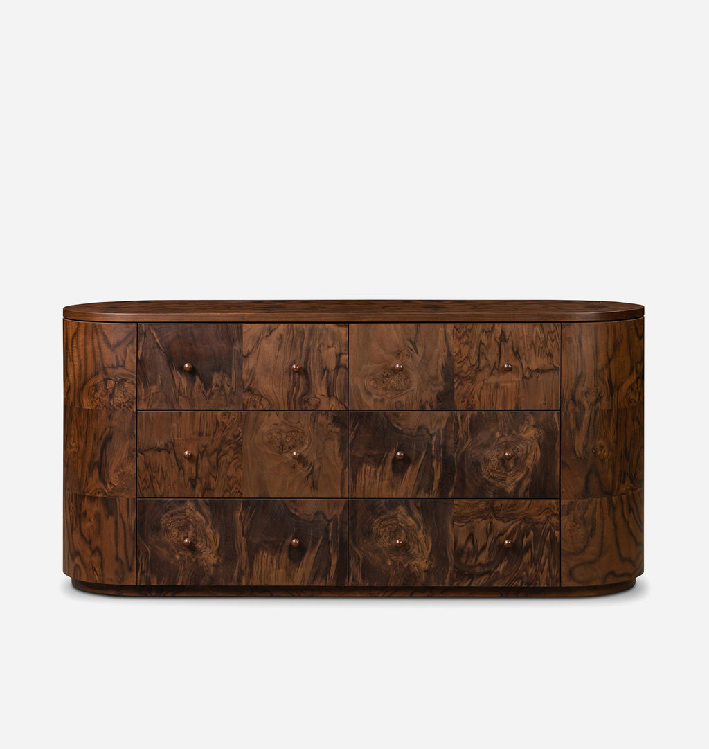 An oval-shaped wooden chest of drawers with a rich dark brown burl wood grain finish and small round metal knobs, set against a plain light gray background.