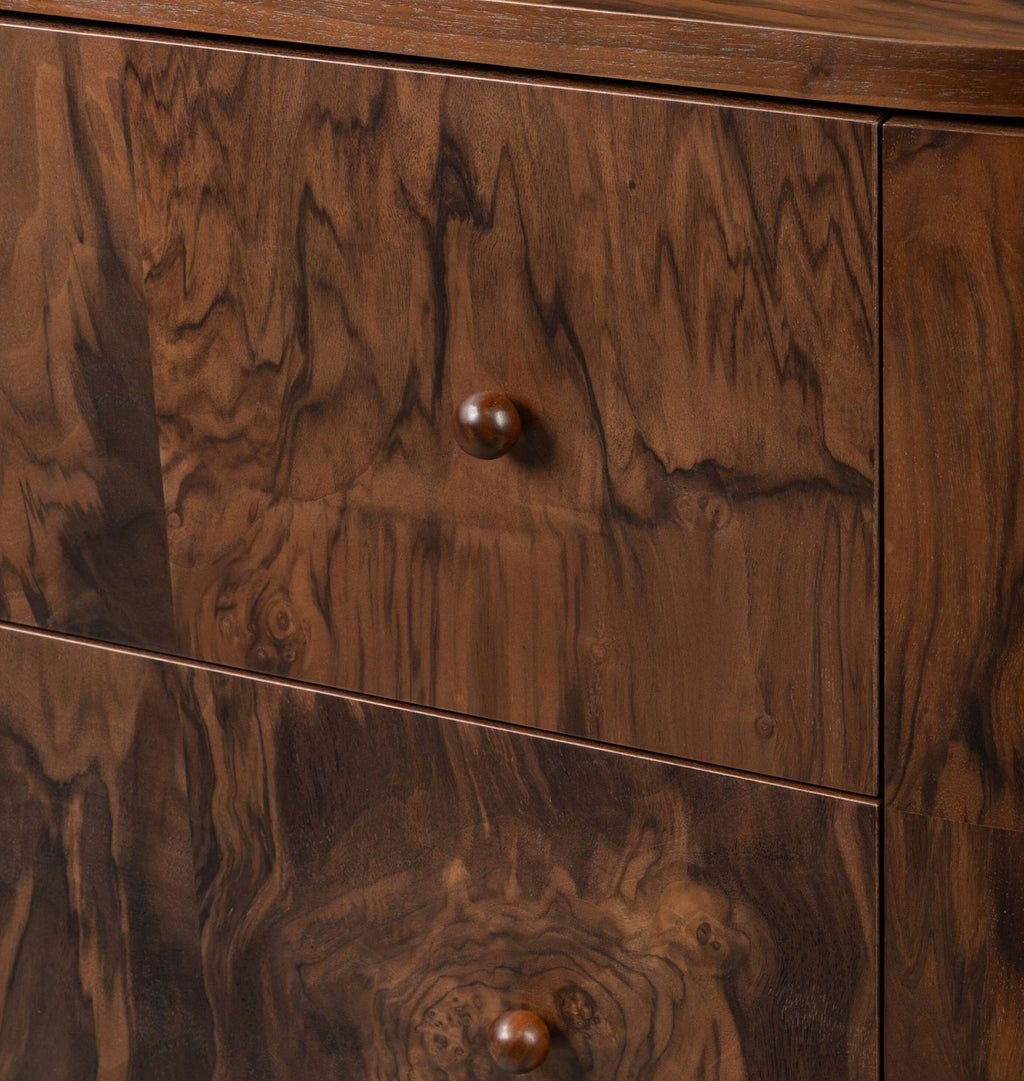 Close-up of a dark wood dresser with two drawers, featuring rich walnut-like grain patterns and round wooden knobs.