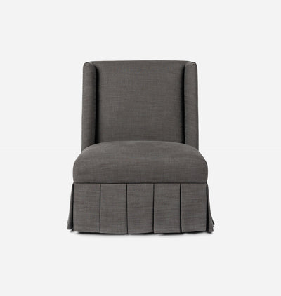 A dark gray upholstered accent chair with a high back, winged arms, and a pleated skirt base, shown against a plain white background.
