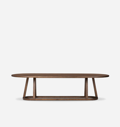 A modern oval dining table with a dark brown wood grain finish and a sculptural wood base, shown against a plain light gray background.