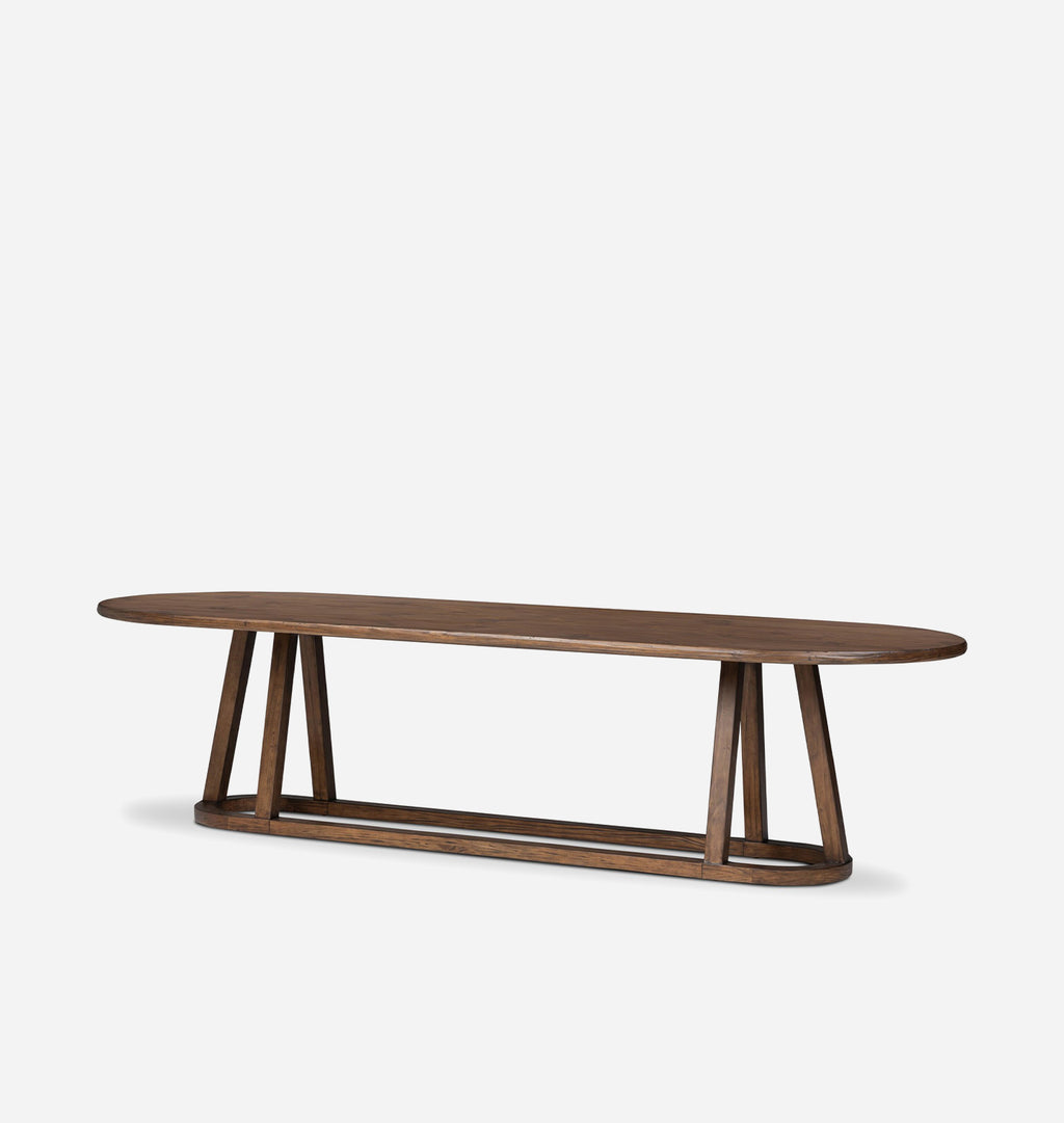 A modern oval wooden dining table with a dark brown finish and a sculptural A-frame base, shown on a light gray background.