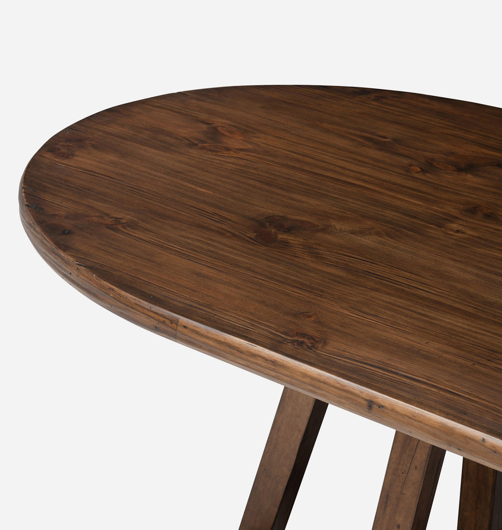 Close-up of a dark brown wooden table showing the rounded oval tabletop grain and part of the wooden legs against a light gray background.