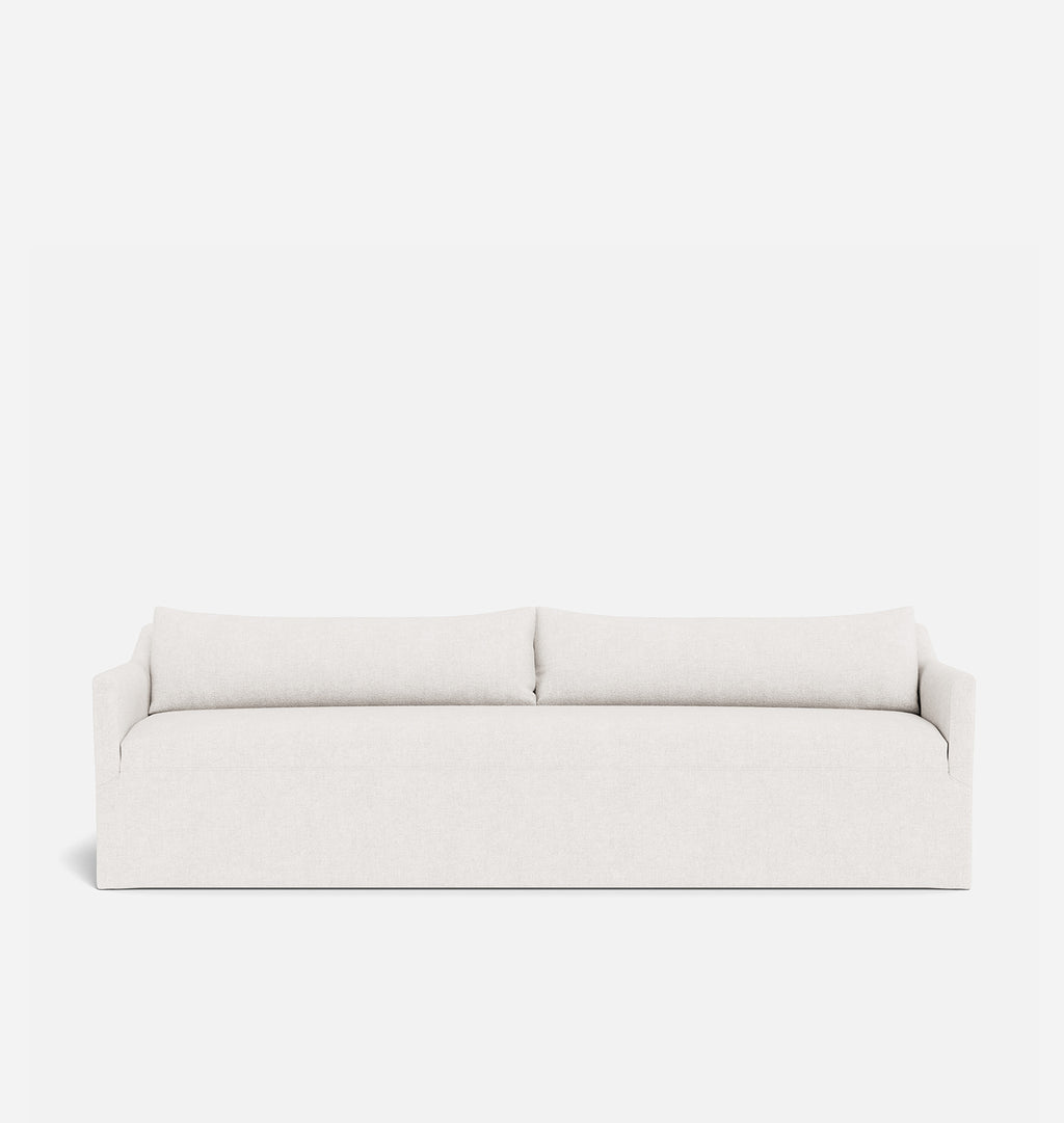 A modern low-profile sofa upholstered in a light cream or off-white textured fabric, featuring two loose back cushions and square armrests, shown against a solid white background.