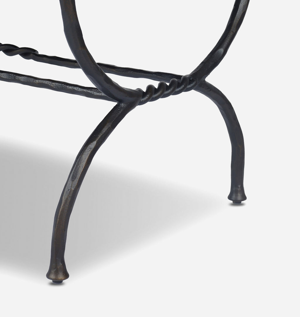 Close-up of a black wrought iron leg with twisted rope detailing and a tapered foot, set against a light gray background.