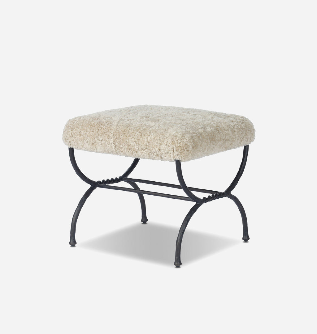 A square ottoman stool with a fluffy cream-colored sheepskin upholstered top and a black metal frame with curved legs, shown on a light gray background.