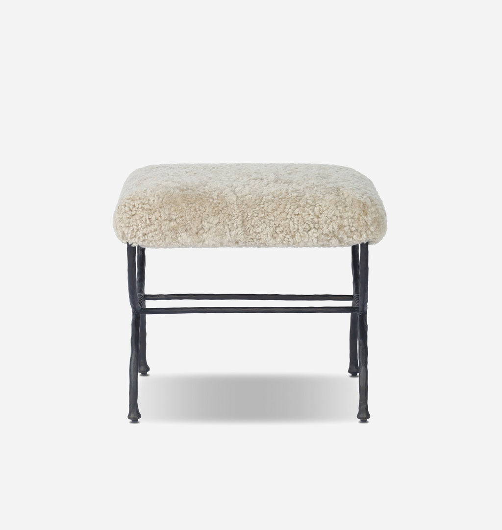 A square stool with a fluffy cream-colored sheepskin upholstered seat and a black metal frame, shown against a plain light gray background.