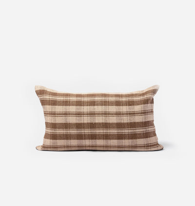 A rectangular throw pillow with a brown and beige plaid pattern, photographed against a clean, light gray background.