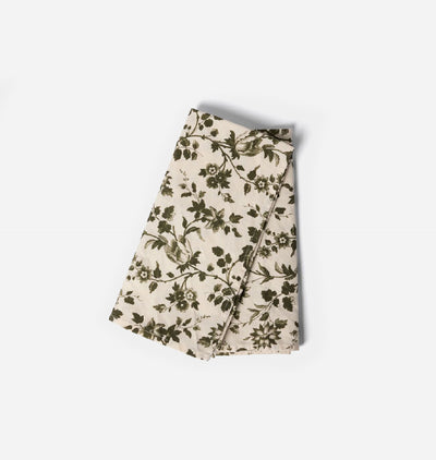 A folded cream-colored fabric item, likely a scarf or napkin, featuring an all-over dark olive green floral and bird pattern, shot on a clean white background.