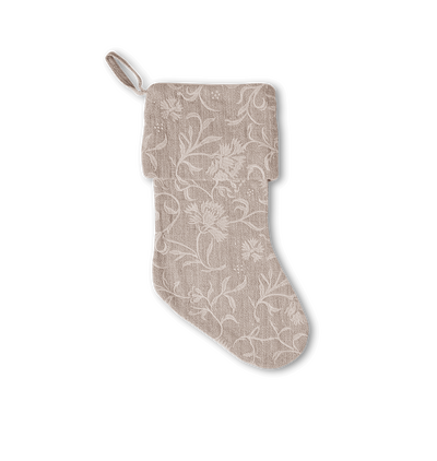 A beige fabric Christmas stocking with a white floral embroidered pattern and a hanging loop, shown against a plain white background.