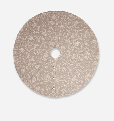 A round tree skirt with a beige and white floral vine pattern, featuring a central hole and a button closure along the front edge, shown against a light gray background.