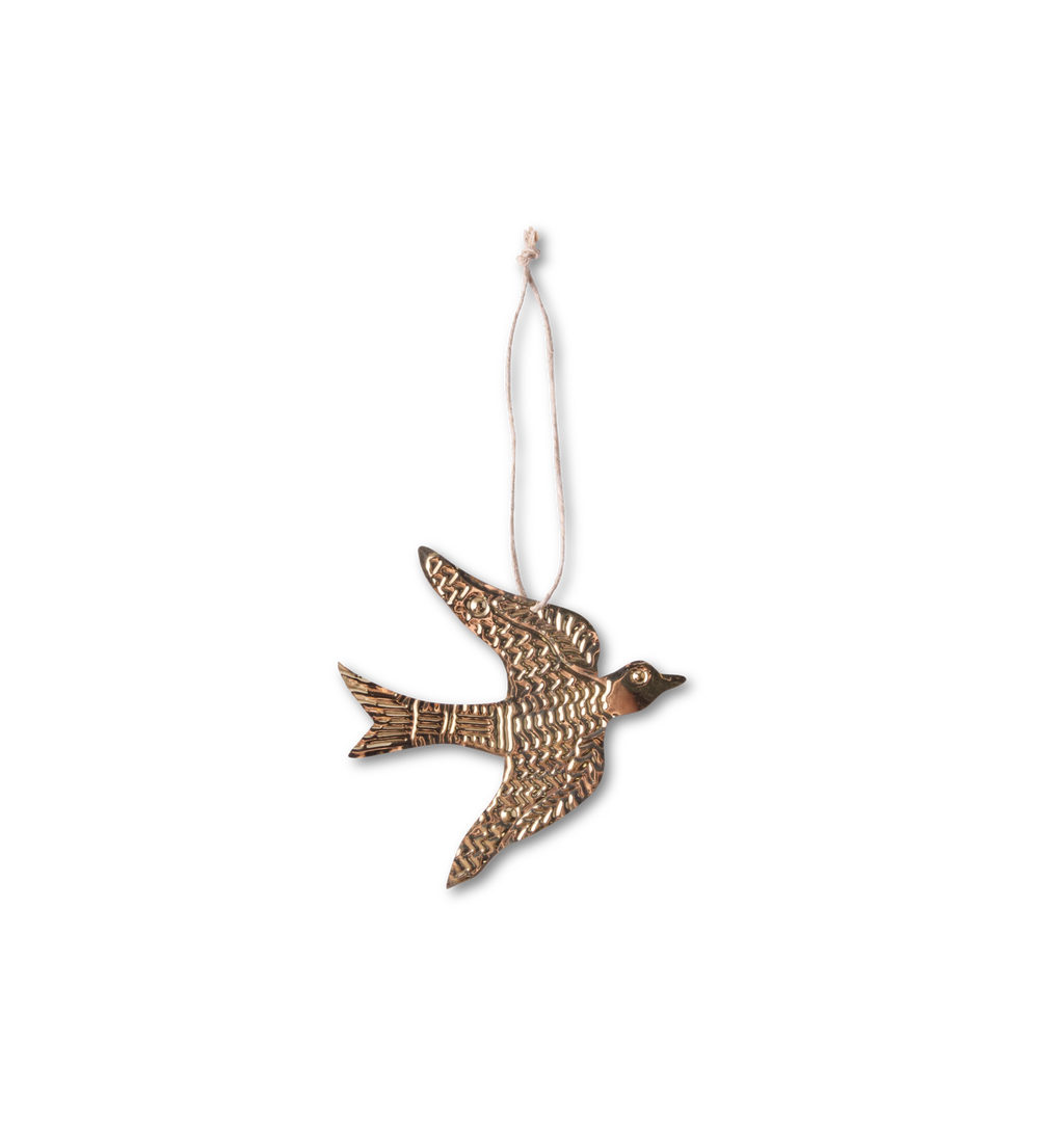 A golden tin sparrow ornament photographed on a white background