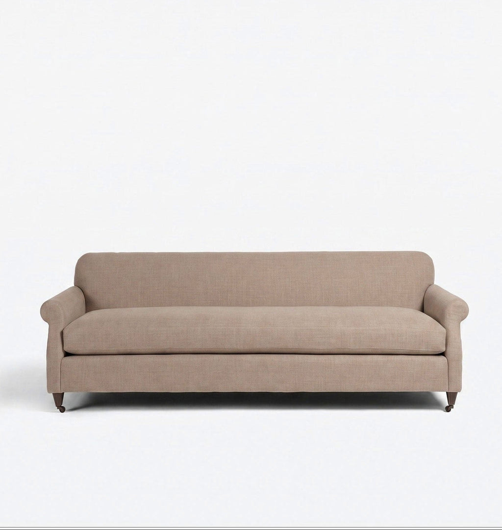 A three-seater sofa upholstered in a textured taupe-beige fabric, featuring rolled arms, a thick seat cushion, and dark wooden legs, shown against a plain white background.