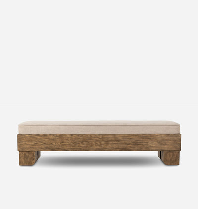 A rectangular upholstered bench with a thick beige fabric cushion and a rustic medium-brown wooden frame, shown against a plain light gray background.