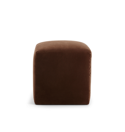 A square brown velvet ottoman with a leather x-stitched accent on the side edge, shown against a plain white background.
