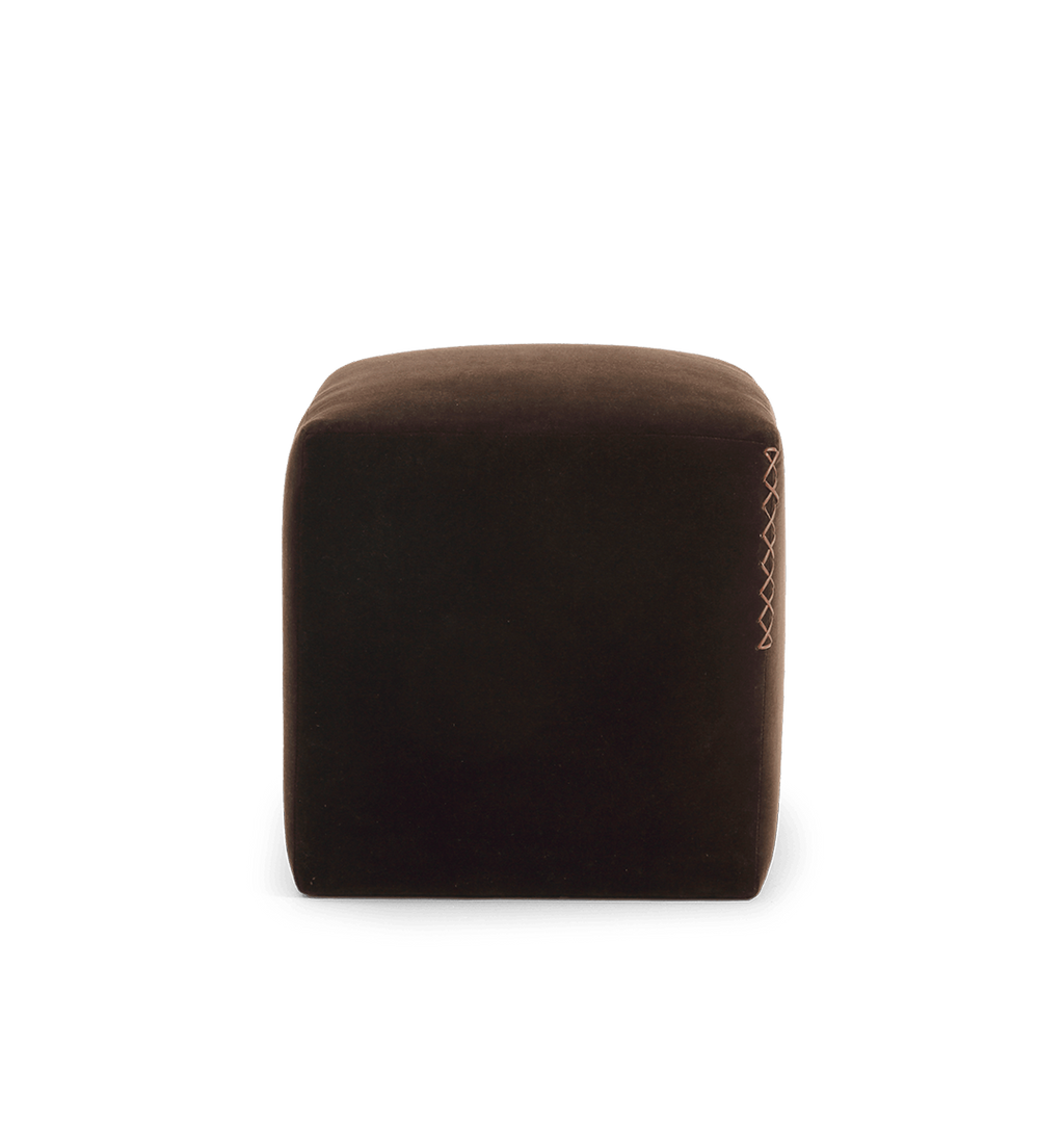 A square dark brown velvet ottoman with a leather x-stitched accent on the side edge, shown against a plain white background.