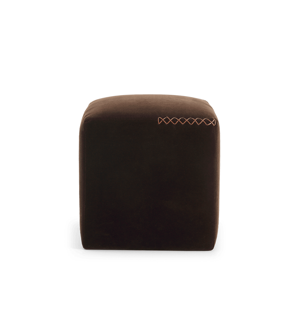 A square dark brown velvet ottoman with a leather x-stitched accent on the top edge, shown against a plain white background.