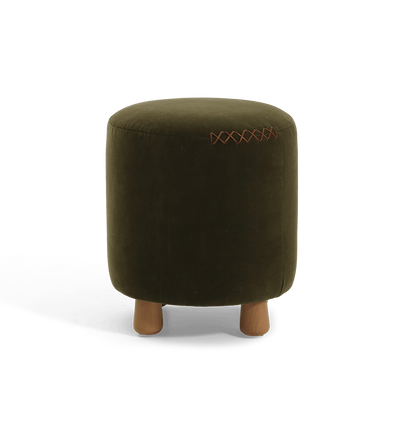 An olive green velvet cylindrical ottoman with short wooden legs and a decorative leather x-stitching on the upper right side, shown against a plain white background.
