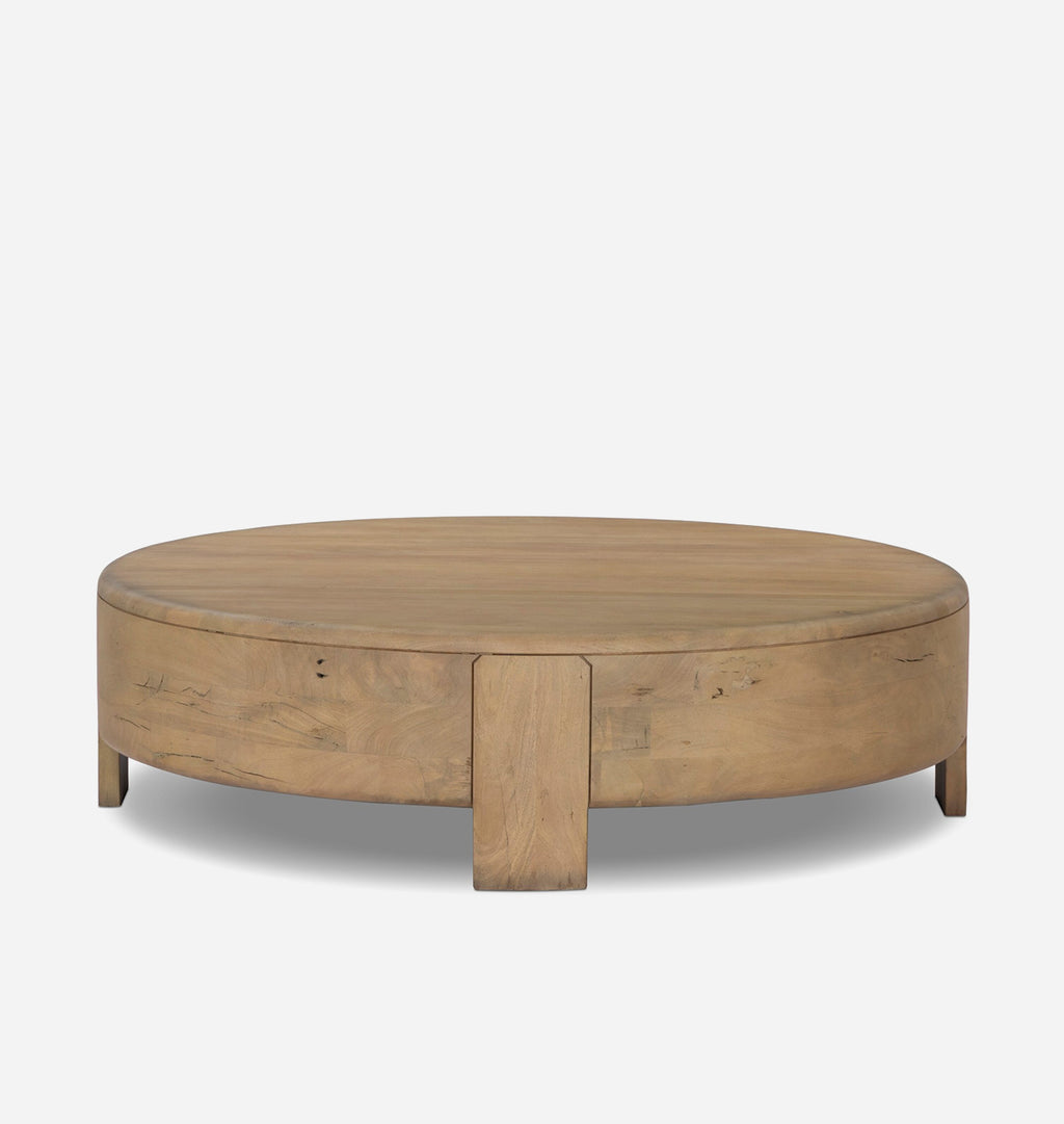 A round wooden coffee table with a natural oak finish, featuring a central pedestal leg and visible wood grain, set against a plain light gray background.