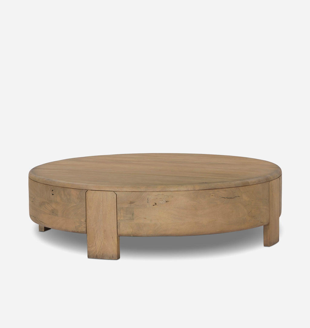 A round wooden coffee table with a natural oak finish, featuring a thick circular top and block-style legs, shown against a plain light gray background.