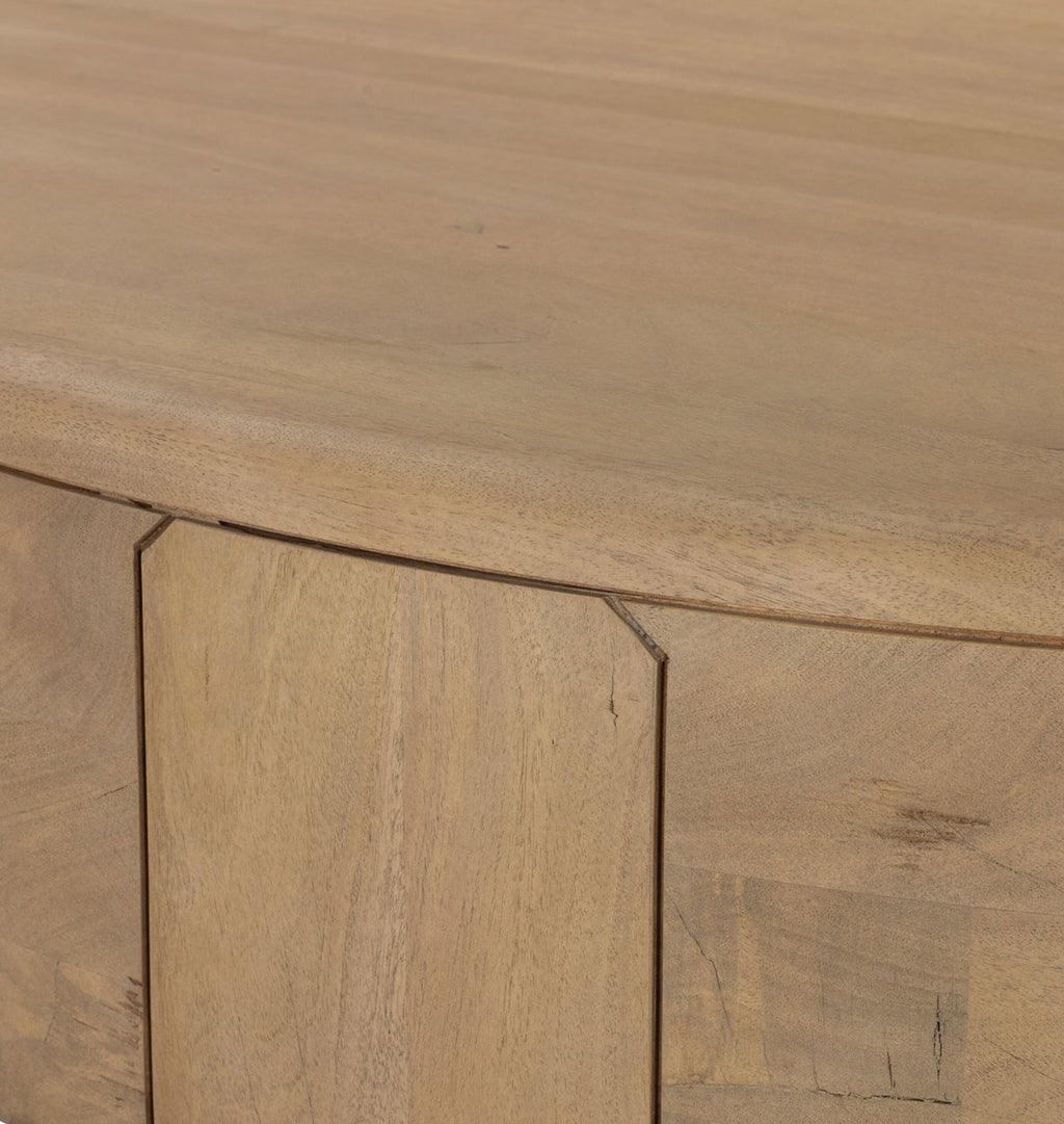 Close-up of a light natural wood furniture surface showing a curved tabletop edge and a matching wooden panel with visible grain and seams.