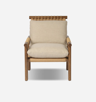 A modern outdoor armchair with a natural wood frame, woven rope details, and thick beige linen cushions, shown against a light gray background.