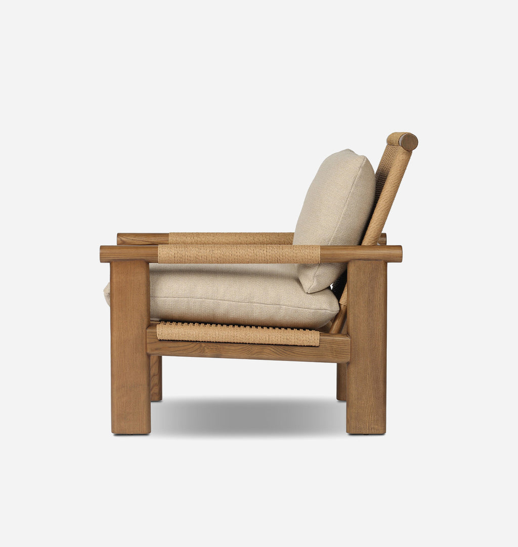 A modern wooden armchair with beige cushions and woven natural fiber accents on the armrests and seat, shown from a side profile against a light gray background.