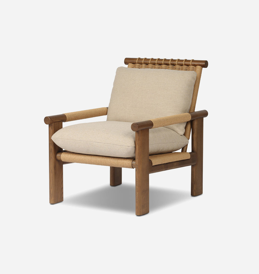 A modern outdoor armchair featuring a warm brown wooden frame, woven rope details, and thick beige cushions, shown against a light gray background.