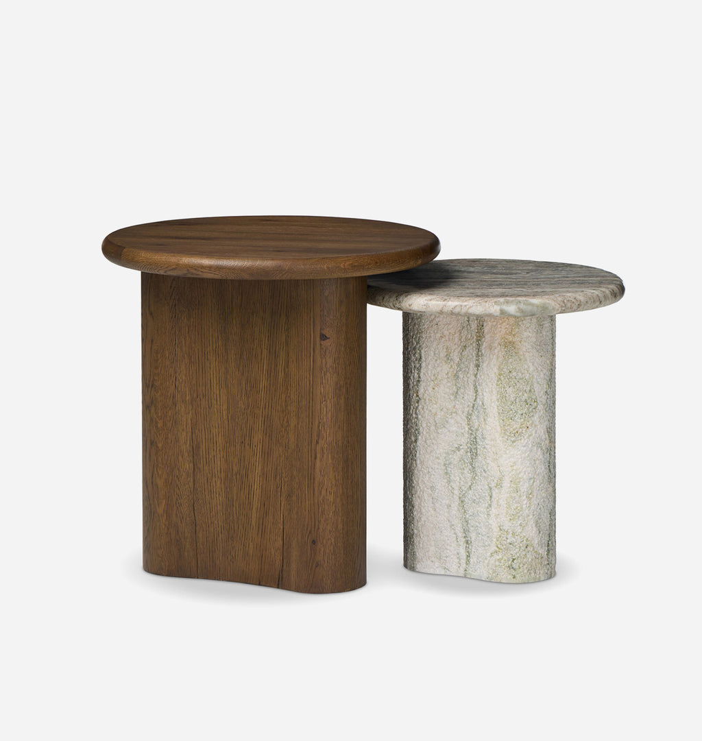 Two modern nesting side tables on a light gray background: one with a round dark brown wooden top and block base, and one with a round light gray marble top and matching stone base.