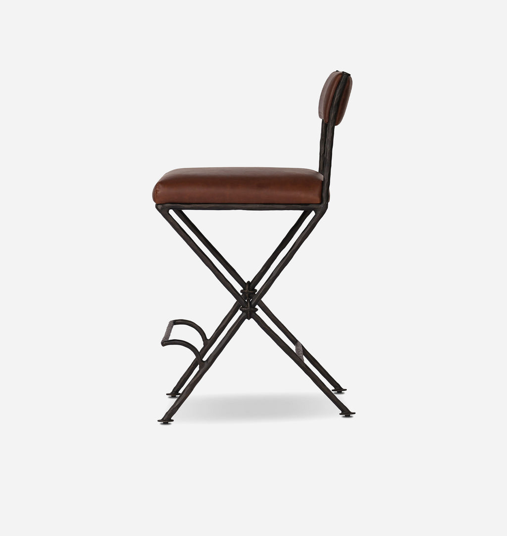 A modern folding bar stool with a brown faux-leather cushioned seat and backrest, supported by a black metal X-frame base with a footrest.