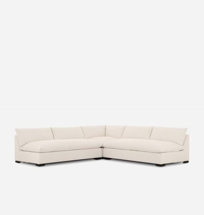 A modern sectional sofa upholstered in a light cream fabric, featuring a chaise lounge and a low rectangular seat, shown against a plain white background.