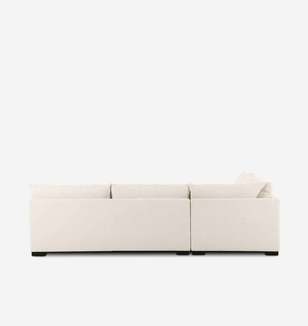 A modern modular sectional sofa upholstered in a light cream fabric, shown from a back view perspective against a solid white background.