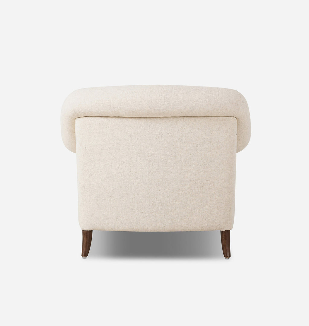 A classic armchair upholstered in a warm cream fabric, supported by dark brown wooden legs, shown against a plain white background.
