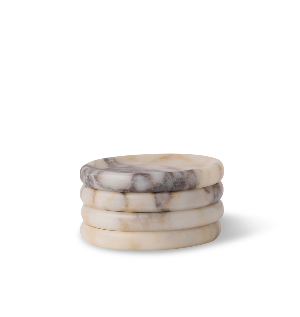 A stack of calacatta viola marble coasters, set of four, with light grey and violet veining set against a white background. 