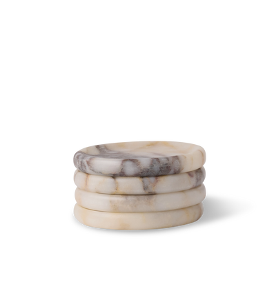 A stack of calacatta viola marble coasters, set of four, with light grey and violet veining set against a white background. 