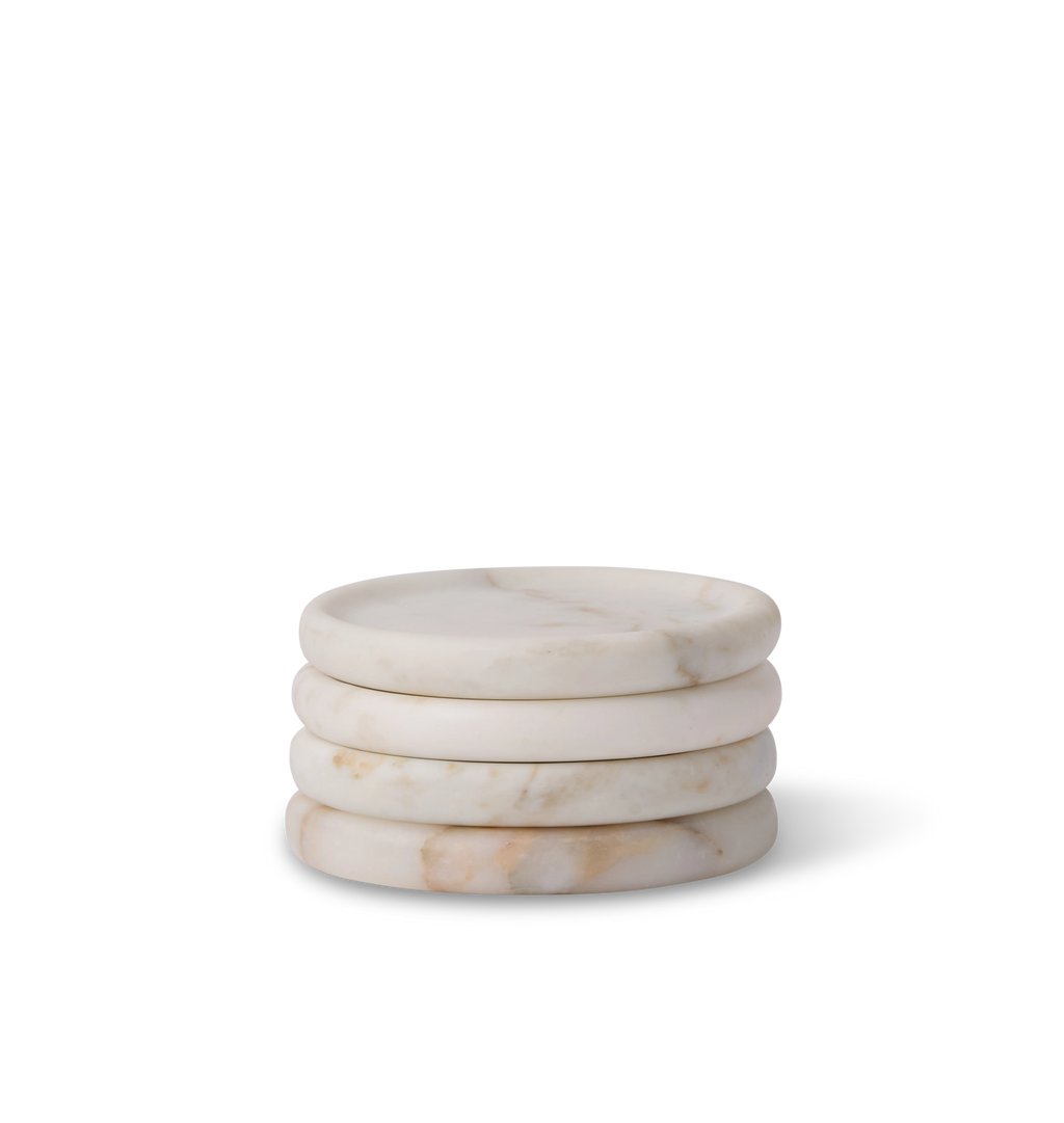 A stack of  a calacatta marble coaster with light grey and gold veining set against a white background.