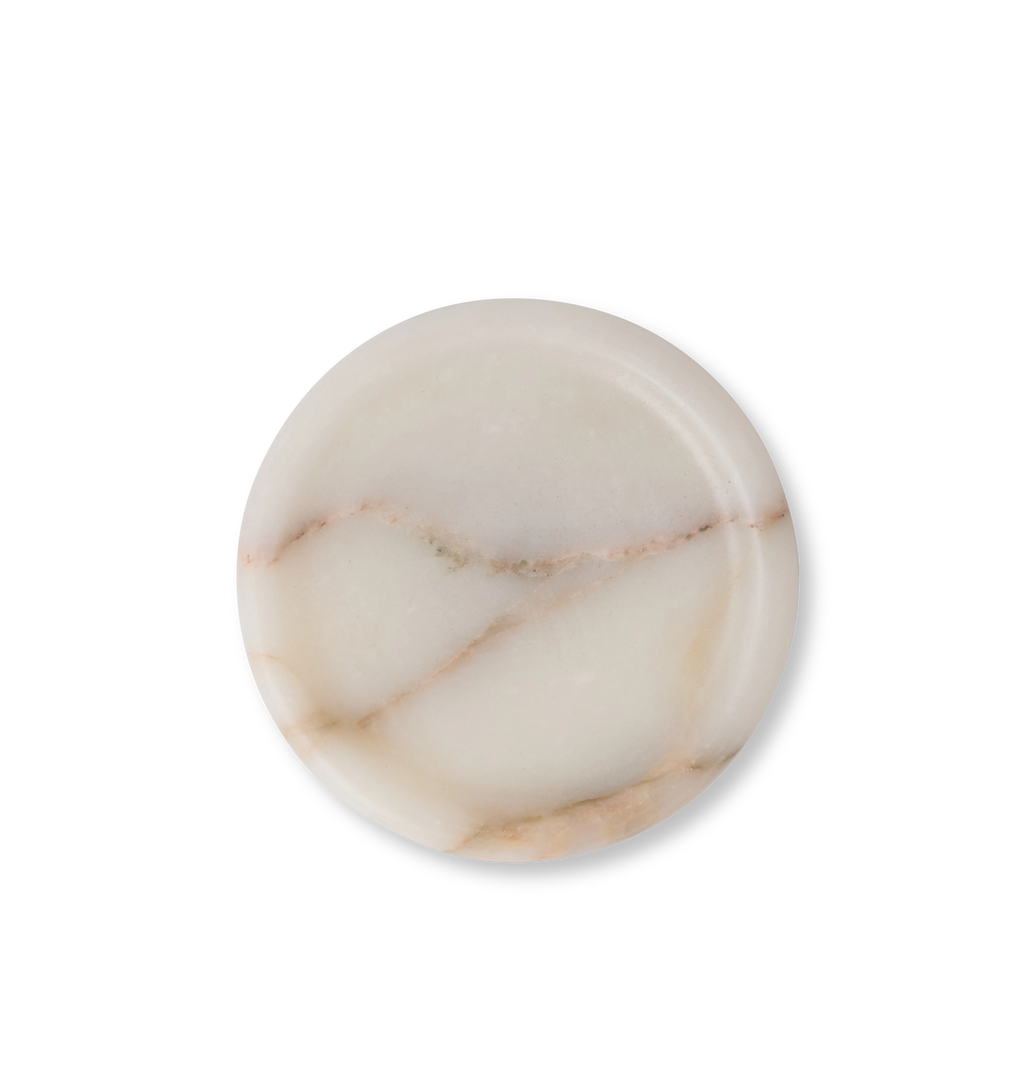A white marble coasters with light grey and gold veining set against a white background. 