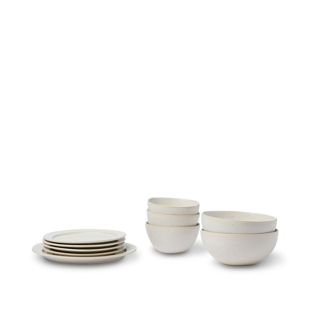 An off white dining set showing a pasta bowl, cereal bowl, salad plate and dinner plate shown on a white background